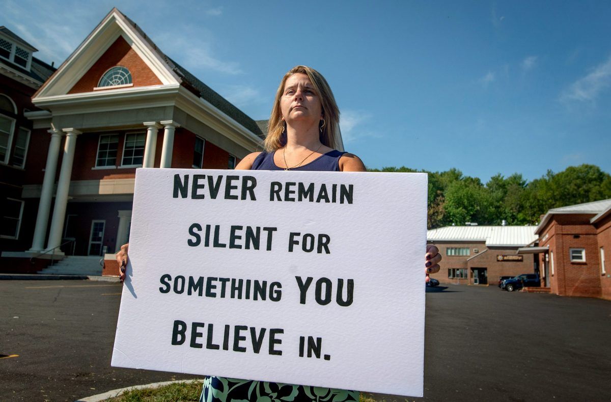 Christina Sugars holds a sign as a message to others to not keep quiet about things that matter to them. Sugars said she cannot fully share her feelings and thoughts about her time as a school resource officer with the Oxford County Sheriff’s Office. Image by Linda Coan O’Kresik/BDN. United States.
