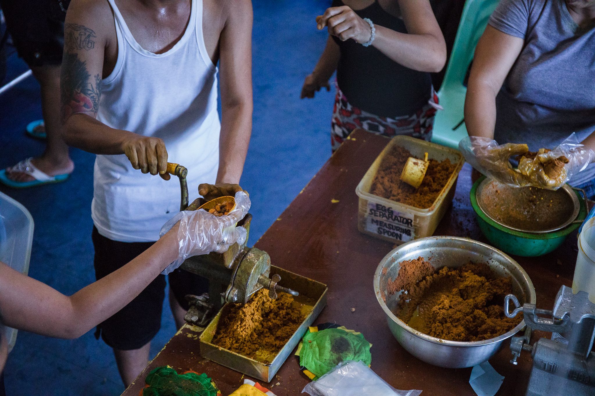 Rise Up organizers teach surviving family members of drug war victims how to make turmeric powder, which they can sell in order to support their families. Image by Pat Nabong. Philippines, 2017.