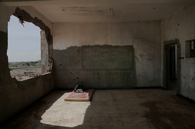 This Feb. 9, 2018, photo shows damage inside a classroom of a school that turned into a camp for displaced persons in Khanfar, Abyan, Yemen. Because of the country’s civil war, damaged buildings are hollowed-out versions of their former selves, a testament to past lives and aspirations of inhabitants who now scrape by on aid handouts and the bare minimum for survival. Image by Nariman El-Mofty. Yemen, 2018.

