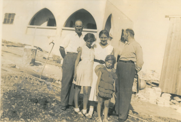Shula Lavyel and her younger sister, Avivit, with their father (right) and his two siblings, in front of their house in Haifa being built. Image courtesy of Shula Lavyel. British Mandate of Palestine, 1935.