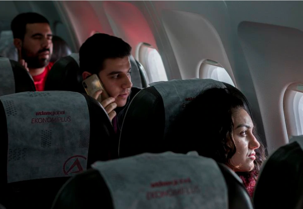 Zahra Ahmad looks out the window of an Atlas Global flight before departing to Erbil, Iraqi-Kurdistan, from Istanbul Atatrk Airport in Istanbul, Turkey on Monday, Feb. 4, 2019. Image by Brontë Wittpenn. Turkey, 2019.