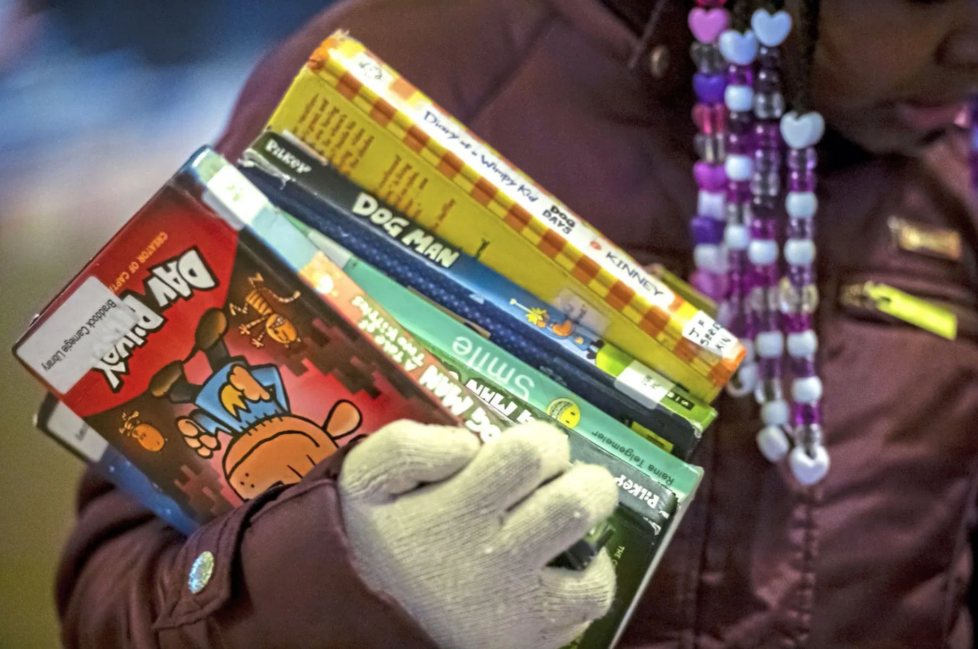 Kee’Miyah holds a stack of books that she plans on checking out from Braddock Carnegie Library. Image by Michael M. Santiago/Post-Gazette. United States, 2019.