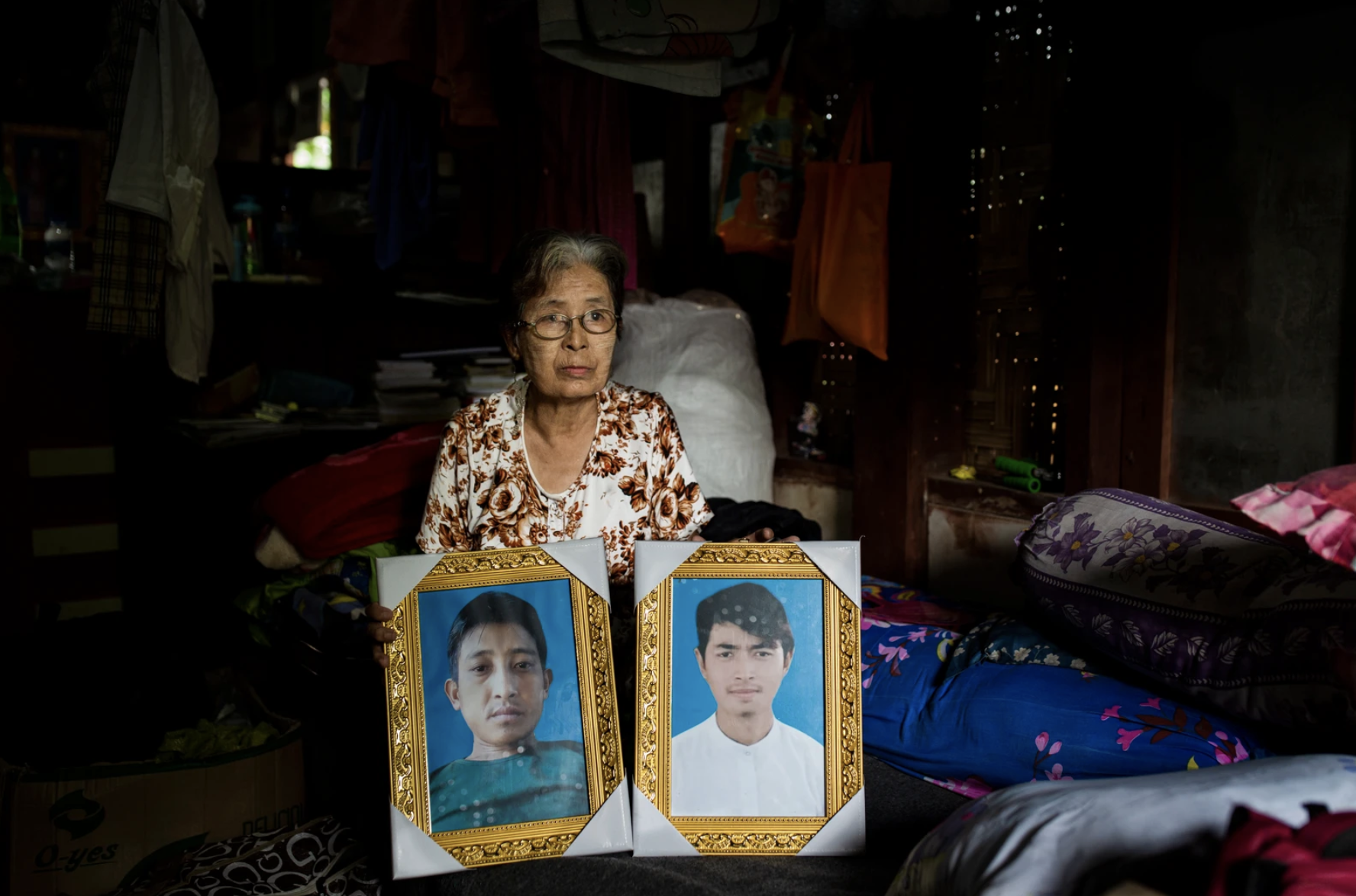 La-Ung Bawk Jan, 73, shows photos of her son-in-law, Nhkum La Di, and her grandson, Nhkum Awng Li, in her home in Myitkyina, Kachin State, Myanmar. Image by Hkun Lat. Myanmar, 2020. 