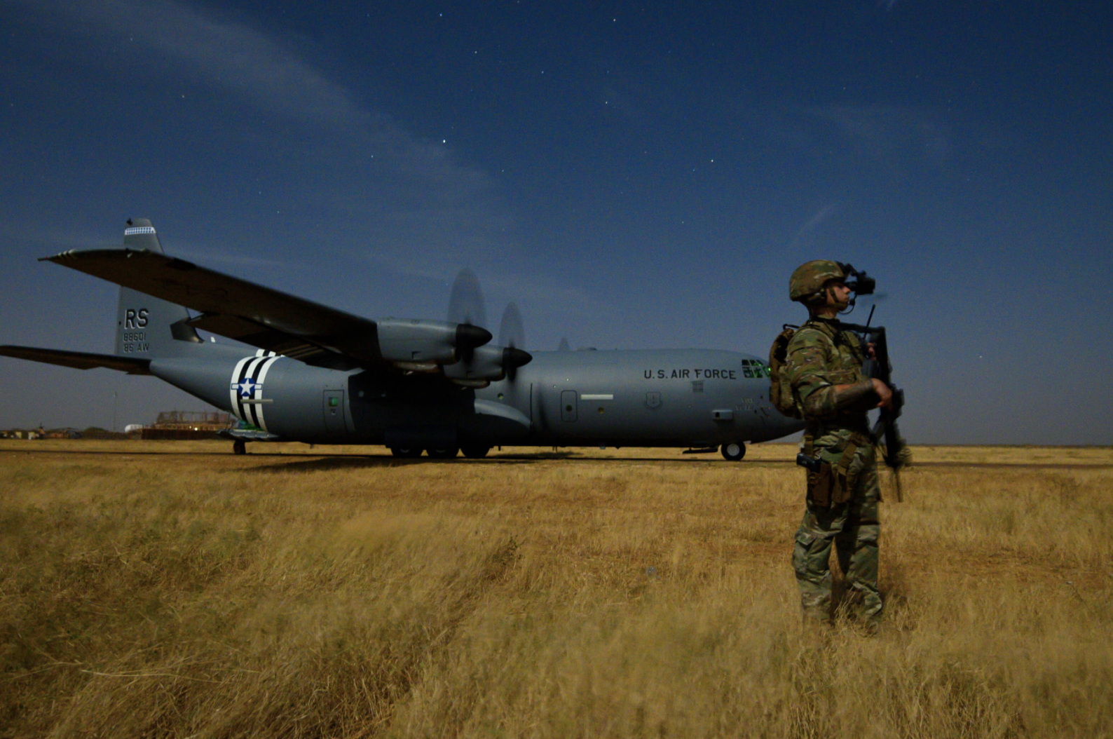 U.S. Army Spc. Christopher Andres, infantryman assigned to Task Force Guardian, 41st Infantry Brigade Combat Team (IBCT), 1-186th Infantry Battalion, Oregon National Guard, provides security for a 75th Expeditionary Airlift Squadron (EAS) C-130J Super Hercules during unloading and loading operations in Somalia on February 6, 2020. Image by U.S. Air Force/Tech. Sgt. Christopher Ruano. Somalia, 2020.