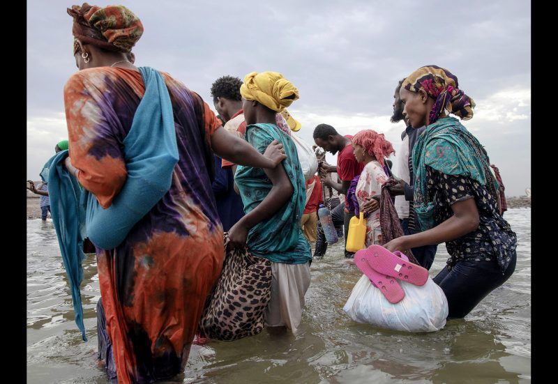 Ethiopian migrants disembark from a boat on the shores of Ras al-Ara, Lahj, Yemen, July 26, 2019, after being smuggled across the Bab el-Mandeb strait from Djibouti. Loaded into a 50-foot-long open boat in darkness, the migrants were warned not to move or talk during the eight-hour crossing. Most had never seen the sea before. Image by AP Photo / Nariman El-Mofty. Yemen, 2019.