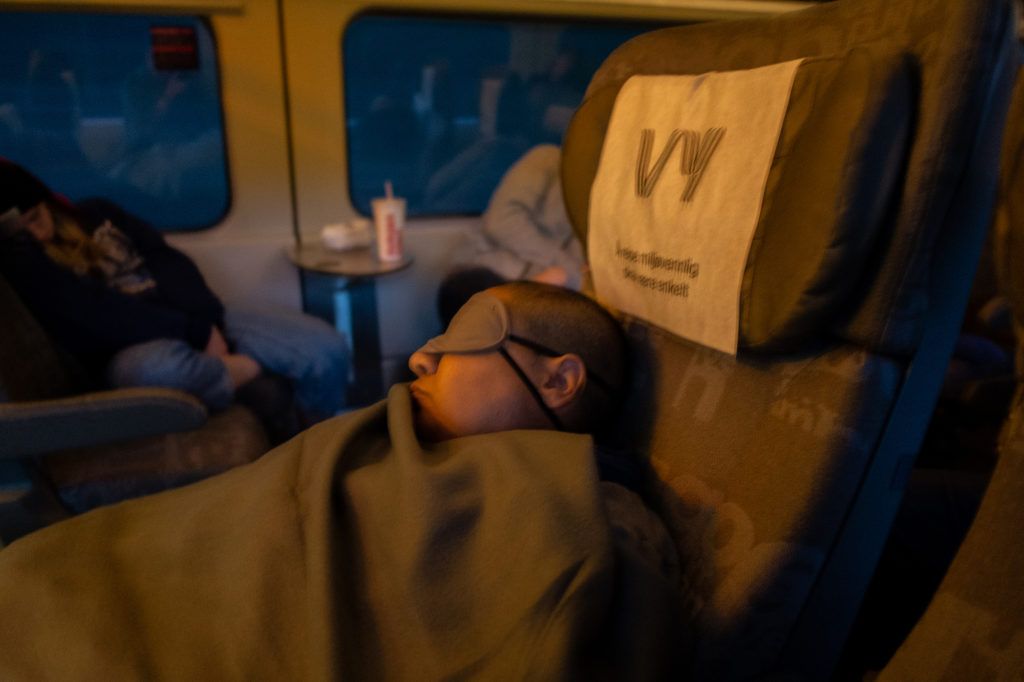 Wael catches some shut-eye on an overnight train between Bergen and Oslo. Image by Bradley Secker. Norway, 2020.