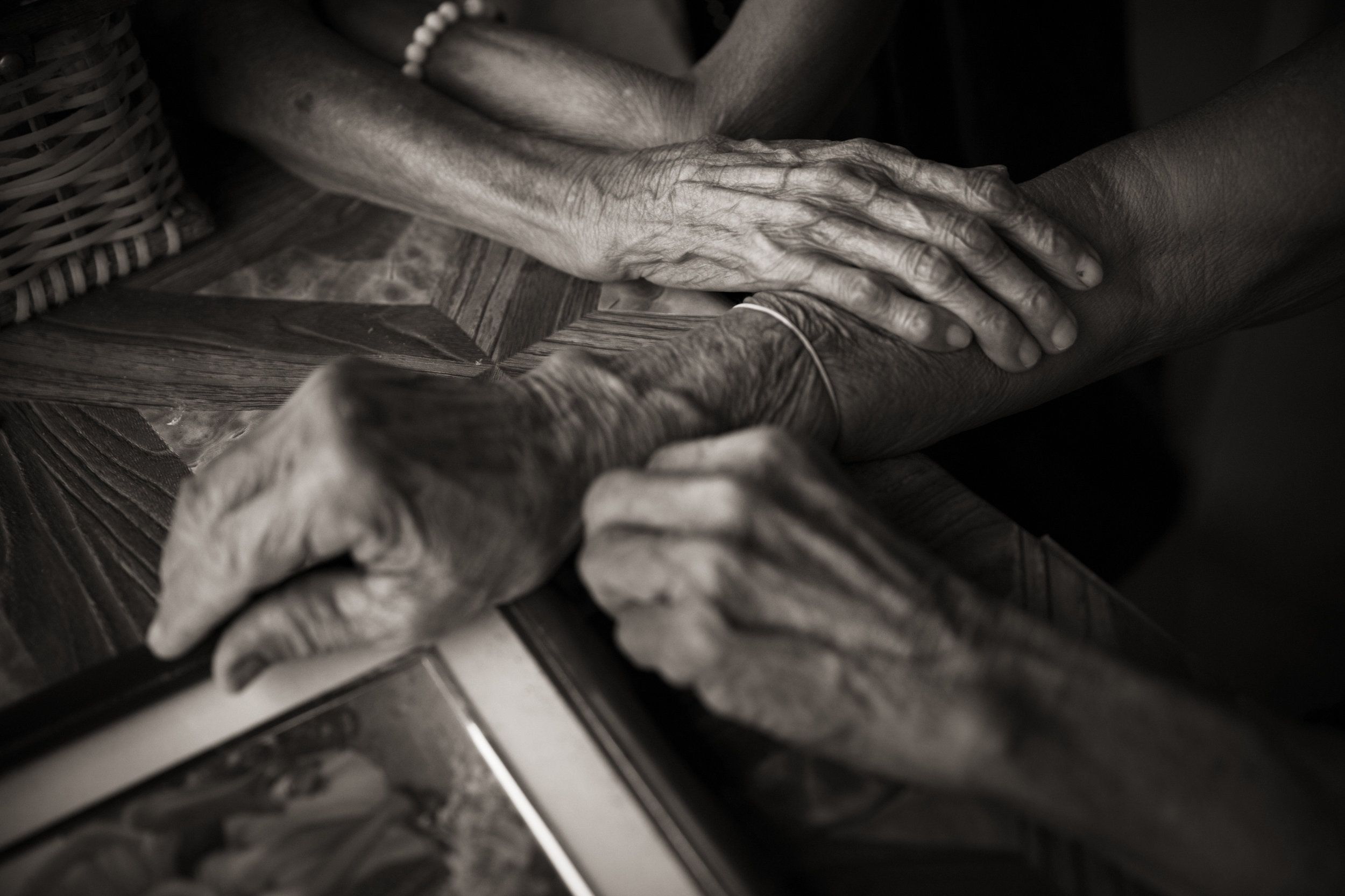 Isabelita Vinuya, Belen Alarcon Culala and Maria Lalu Quilantang clasp hands. The three women were repeatedly raped as children by Japanese imperial soldiers in their village of Mapaniqui. Image by Cheryl Diaz Meyer. Philippines, 2019.