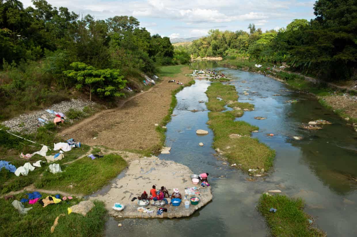 Women wash laundry along the Meille River, a tributary to the Artibonite River, the longest waterway in Haiti, which carried cholera through the country. Image by Allison Shelley. Haiti, 2020.