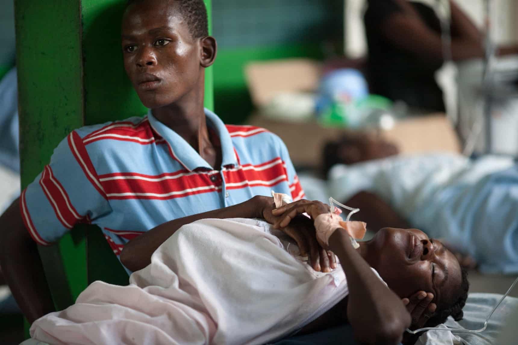 A boy cares for a relative in a ward at a cholera treatment centre run in Petite Rivière, a riverfront town in Artibonite, Haiti. Image by Allison Shelley. Haiti, undated.