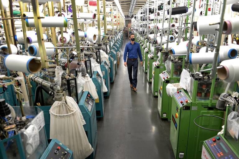 ASHEBORO, NORTH CAROLINA - Jordan Schindler, Founder and CEO of Nufabrx, walks through a row of machines producing Theramasks at the Bossong Medical plant in Asheboro, N.C. on Thursday, July 16, 2020. Image by Jeff Siner/The Charlotte Observer/North Carolina News Collaborative. United States, 2020.