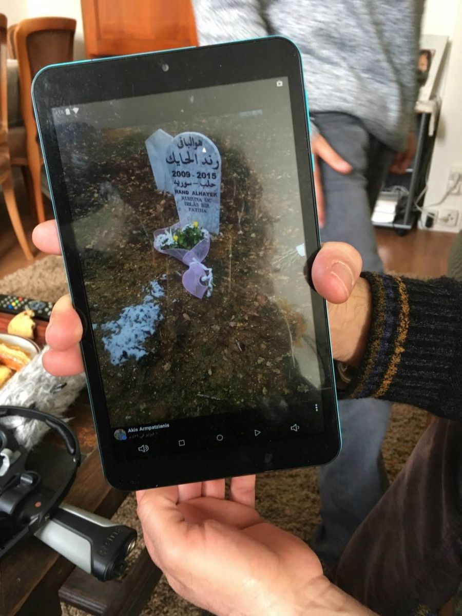 Mahmoud al-Hayek shows a photo of his daughter Rand's gravestone in Greece. Rand, 6, was killed by a train after the family crossed from Turkey into Greece as refugees. Image by Jeanne Carstensen. France.