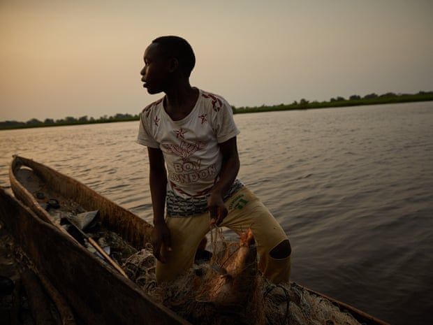 A boy sells his day’s catch on the Congo river in Équateur province. Image by Hugh Kinsella Cunningham. Congo, 2019.