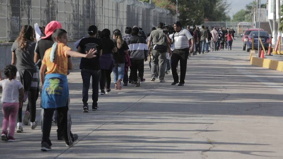 A line of migrants is led toward the Mexican Instituto Nacional de Migracion where they will be processed once they’re sent back to Mexico from the United States. Image by Jose A. Iglesias. Mexico, 2019.