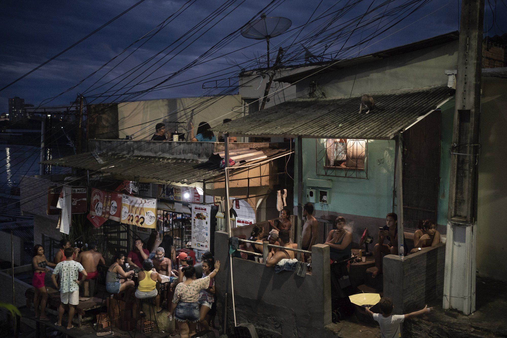 People gather outside a bar in Manaus, Brazil, Sunday, May 24, 2020, amid the new coronavirus pandemic. Image by Felipe Dana / AP Photo. Brazil, 2020.