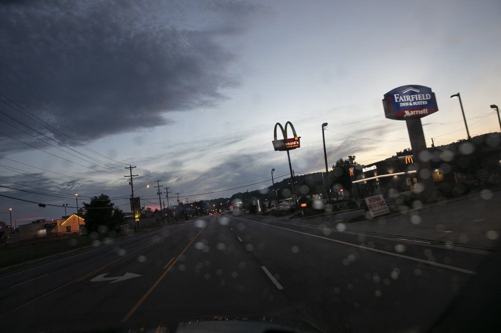 Signs are lit against the dusk sky in Athens, Ohio. Image by Wong Maye-E/AP Photo. United States, 2020.