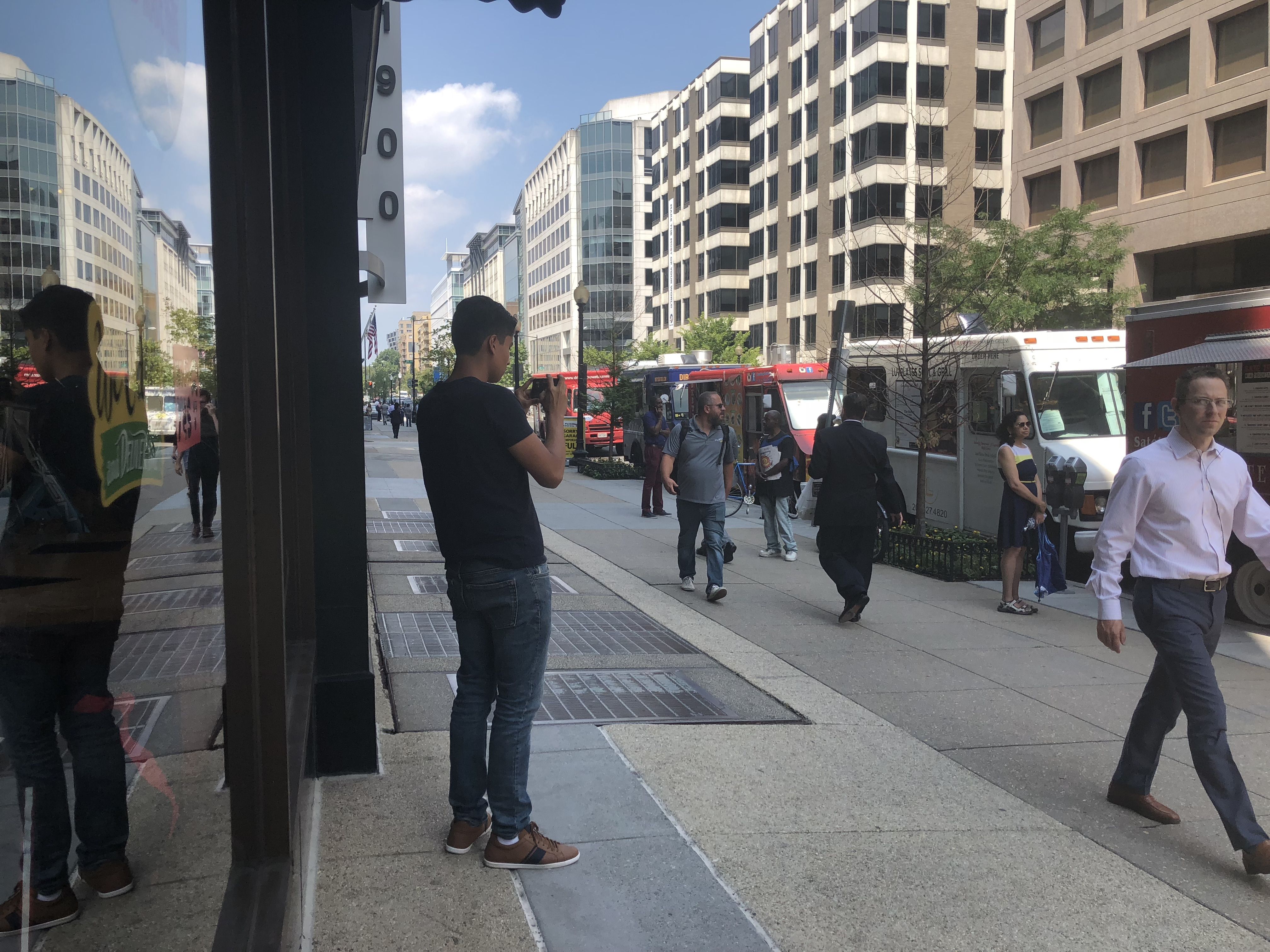 A participant in the Tomodachi Youth Exchange program observes the people walking along a street in Washington, D.C. Image by Kayla Edwards. United States, 2018. 