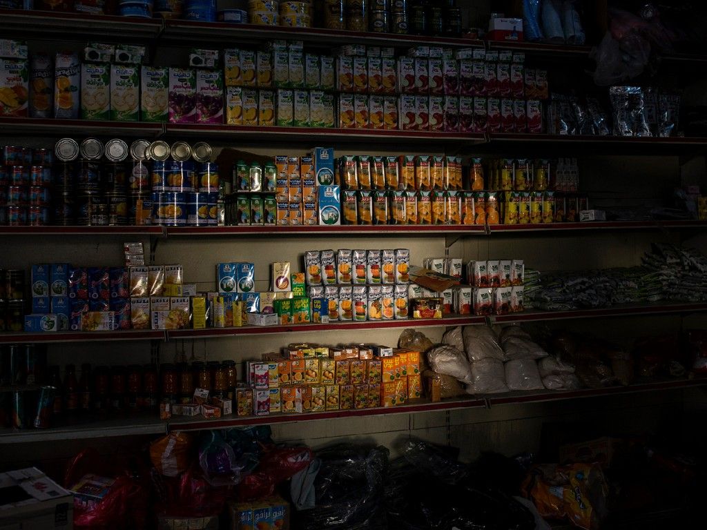 Light shines on goods in a convenience store in Sanaa. Image by Alex Potter. Yemen, 2018. 
