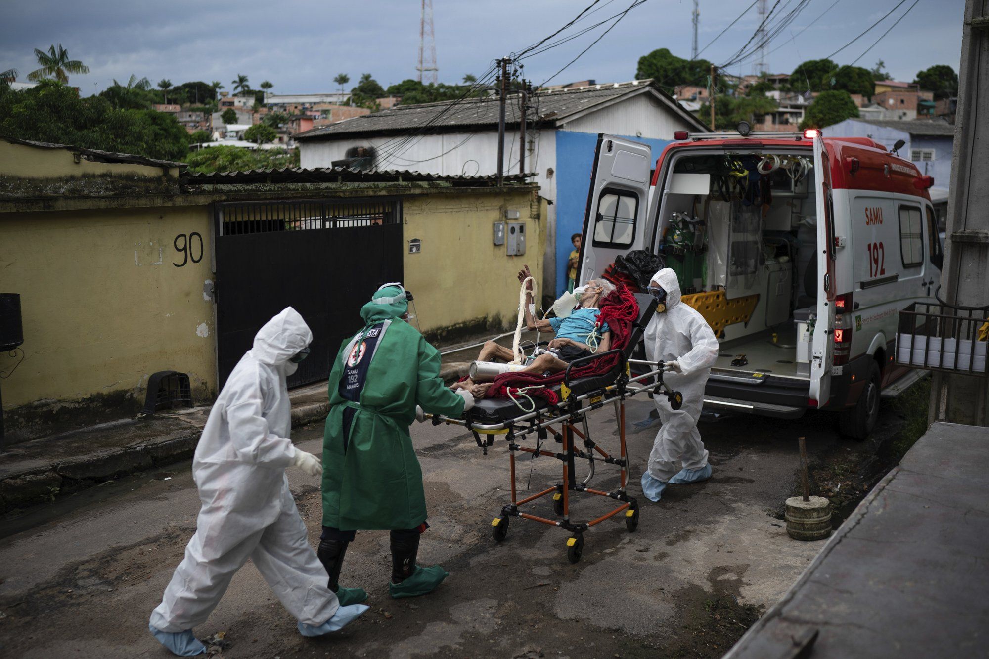 Emergency workers transfer an elderly patient, suspected of having COVID-19, to a hospital in Manaus, Brazil, Wednesday, May 13, 2020. Image by Felipe Dana / AP Photo. Brazil, 2020.