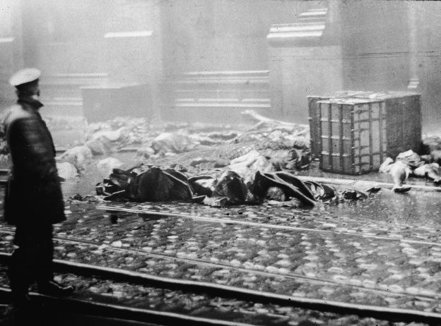 A policeman stands in the street, observing charred rubble and corpses of workers following the Triangle Shirtwaist Company fire in New York City on March 25, 1911.