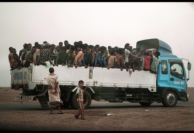 Migrants who arrived by sea are moved by smugglers to a makeshift shelter, called a "hosh" in Arabic, in Ras al-Ara , Lahj, Yemen, July 23, 2019. Most dream of reaching Saudi Arabia, and earning enough to escape poverty. But even if they reach their destination, there is not guarantee they can stay; the kingdom often expels them. Image by AP Photo / Nariman El-Mofty. Yemen, 2019.