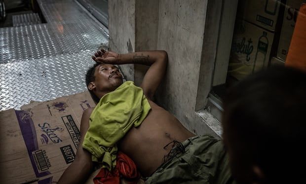 A man under the influence of drugs has passed out in front of a store entrance, a highly dangerous thing to do in Navotas. where there have been dozens of extrajudicial killings since the beginning of Duterte’s “Tokhang” drug war. Image by James Whitlow Delano. Philippines, 2018.