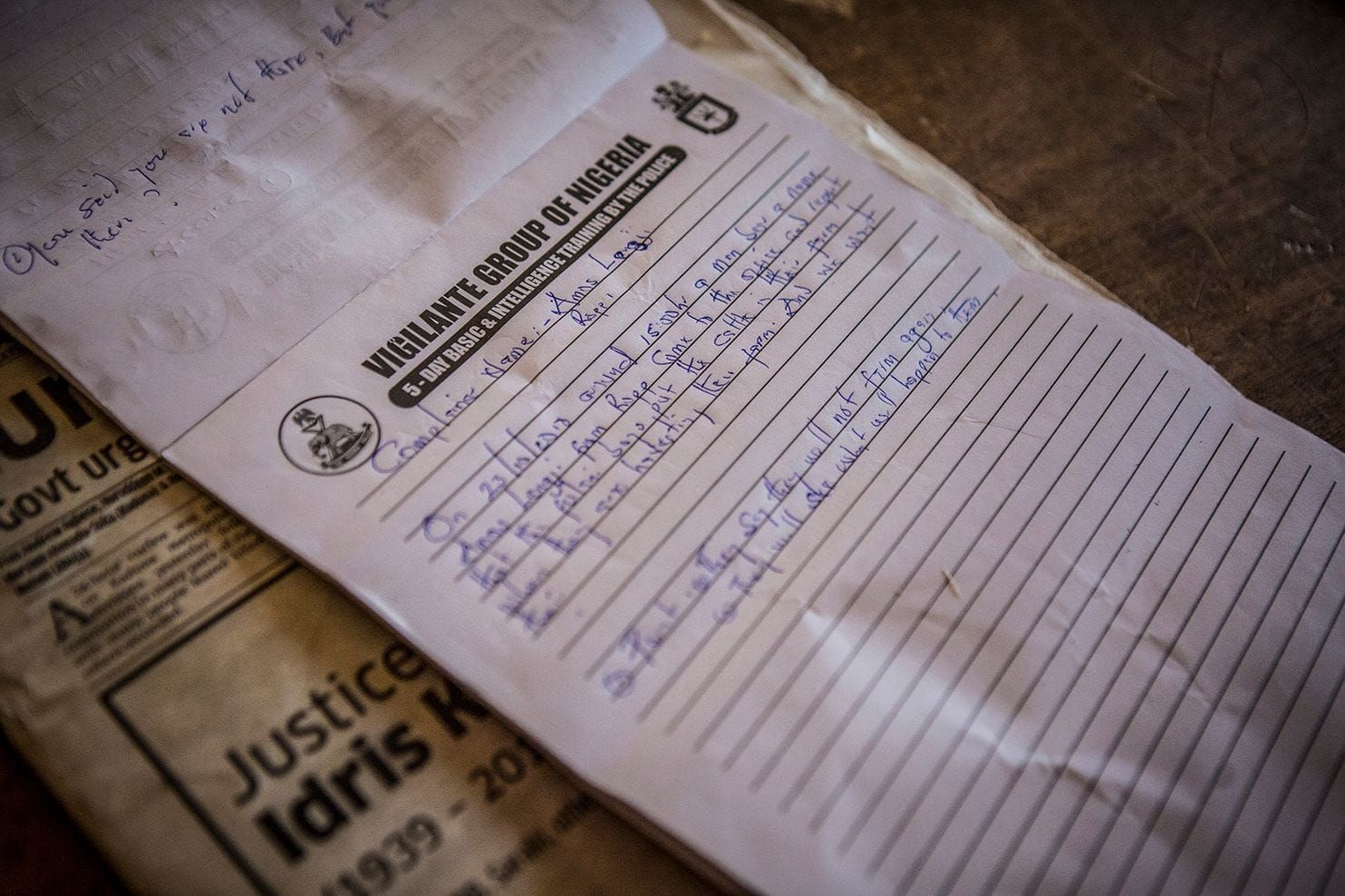 A notepad from a training session for the Barkin Ladi Division of the Vigilante Group of Nigeria is used to take notes during a mediation meeting between a farmer and a herder at the group’s headquarters in Barkin Ladi on Oct. 24. Image by Jane Hahn. Nigeria, 2018.
