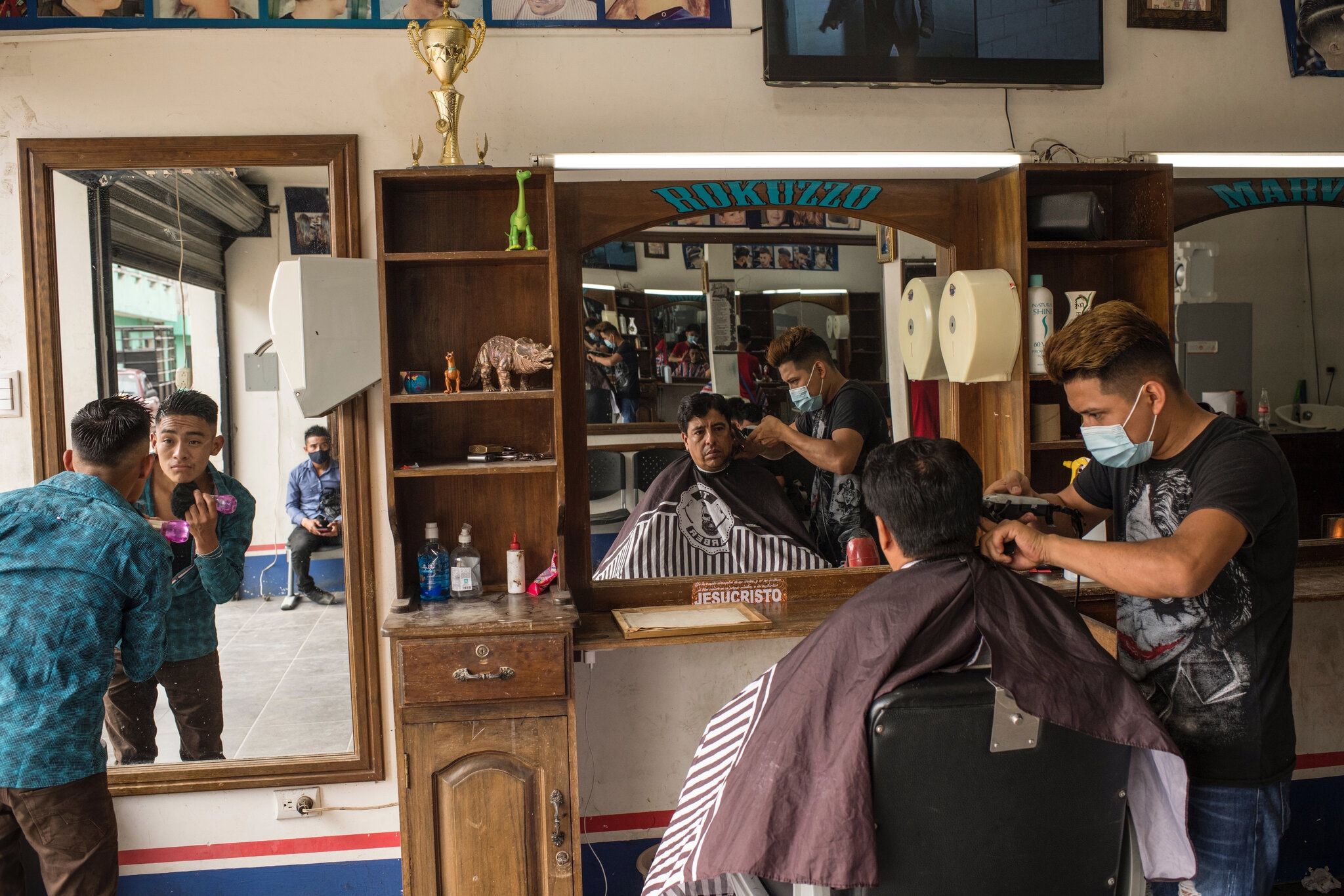 Roberto’s brother, Marvin, at Rokuzzo, the barbershop founded by Roberto in Cubulco. Roberto left the business to his younger brothers before he began his journey to the United States. Image by Daniele Volpe/The New York Times. Guatemala, undated.
