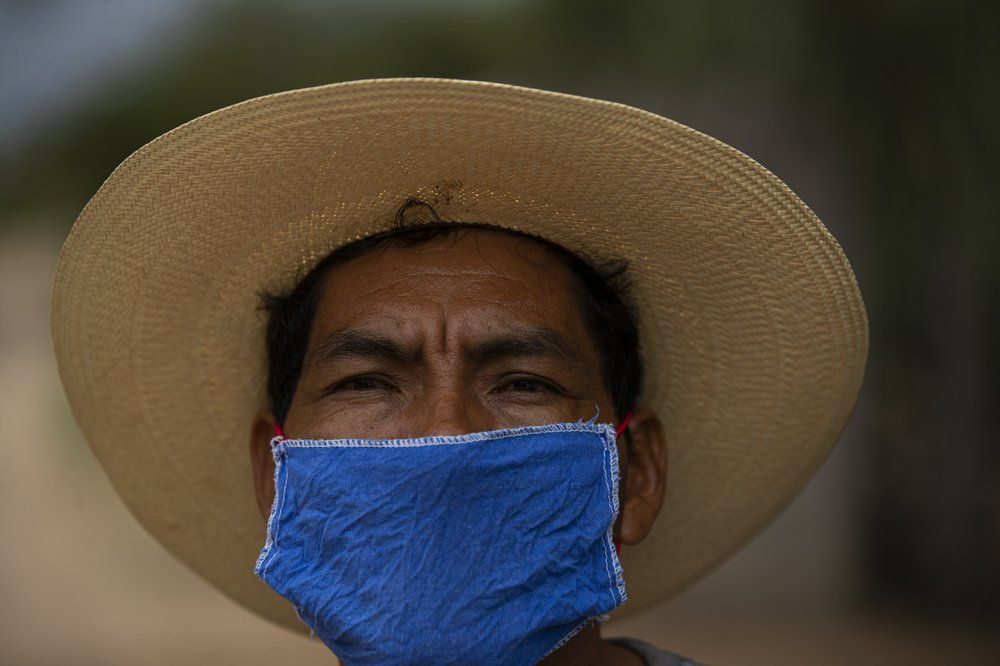 Jorge Vazquez wears a face mask amid the spread of COVID-19 outside his home in San Jeronimo Xayacatlan, a town in Mexico from where nearly a third have emigrated to New York, Wednesday, June 24, 2020. Trained as a nurse, the 42-year-old has returned home for good from New York where he emigrated twice. Image by Fernando Llano/AP Photo. Mexico, 2020.
