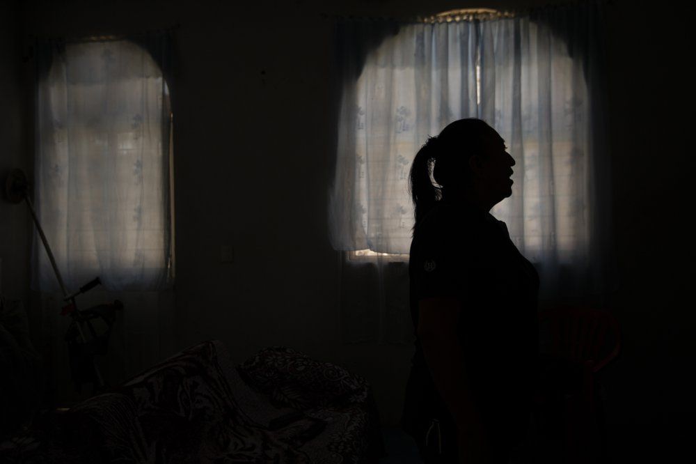 Elisabeth Alvarado stands inside her home in San Jeronimo Xayacatlan, her native town in Mexico, where she stayed behind after her husband Axayacatl Figueroa emigrated to New York in 2005, Friday, June 26, 2020. Their plan was for her to follow and then send for their son, who was 3 at the time, but border agents caught her trying to cross the border five times, and she gave up. Image by Fernando Llano/AP Photo. Mexico, 2020.