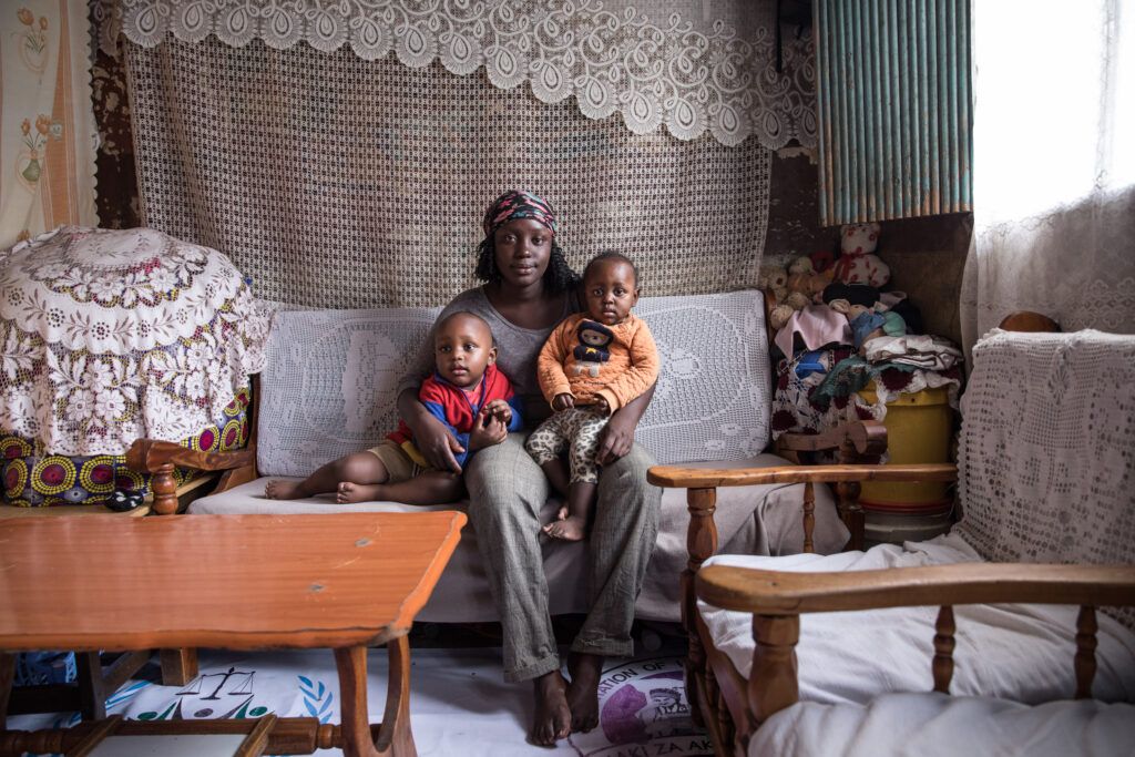 Winnie in her home with her children Reggie (2) and Rhian (1). Image by Sarah Waiswa/The Everyday Projects. Kenya, 2020.

