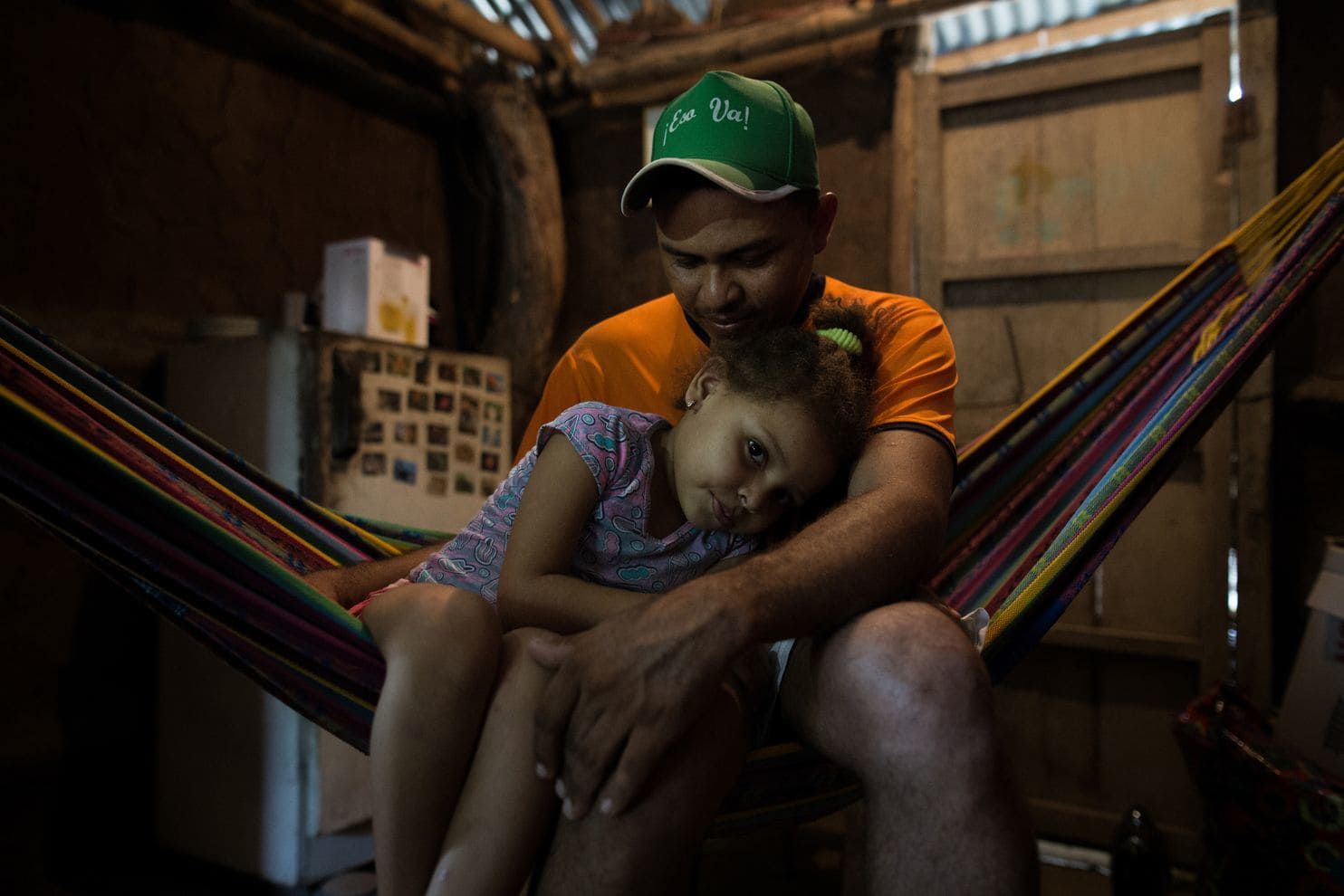 Luis “Lucho” Salgado, 32, with his daughter, Karen, 6, says he prefers not to talk about what happened the day of the 1996 massacre. For many people, it remains too painful. He lost two uncles that day and hopes his daughter will see a better future in this region now that the conflict has ended. Image by Ivan Valencia/For The Washington Post. Colombia, 2018.