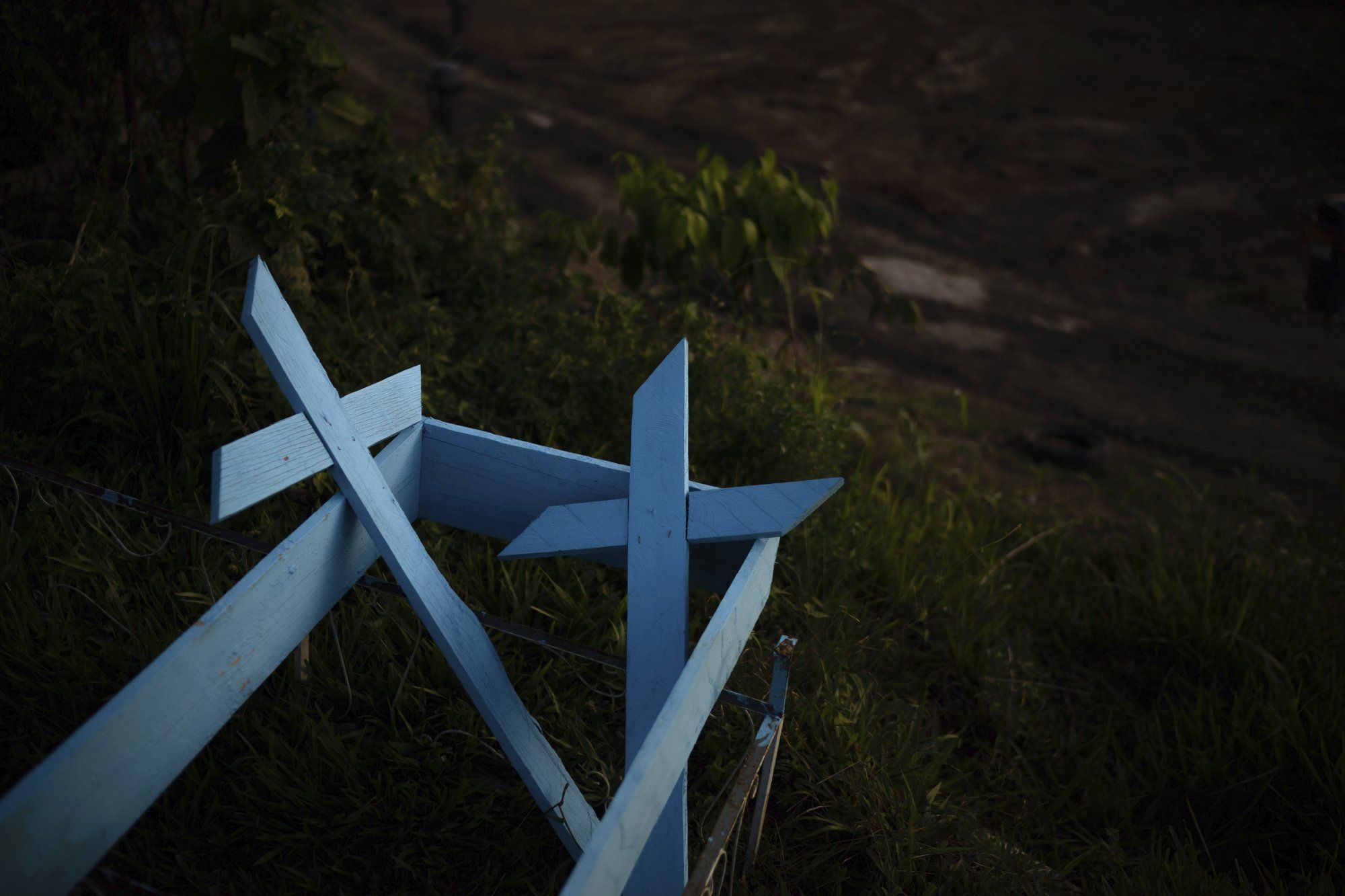 Painted wooden crosses lay on the roadside of a new section of the Nossa Senhora Aparecida cemetery in Manaus, Brazil, Saturday, May 16, 2020. Image by Felipe Dana / AP Photo. Brazil, 2020. 