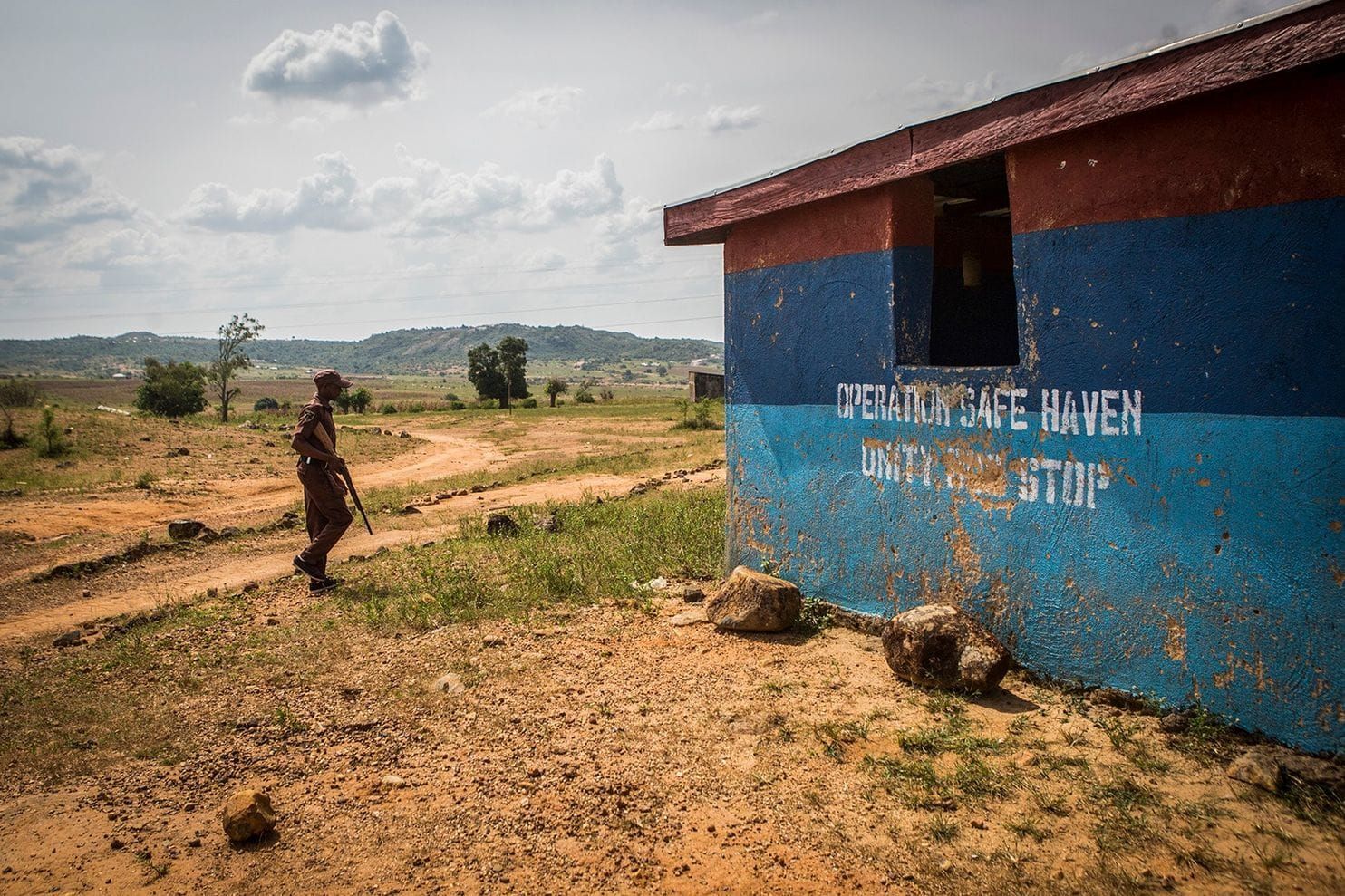 A member of the Vigilante Group of Nigeria, Barkin Ladi Division, stands guard outside an outpost reserved for Operation Safe Haven, run by the Nigerian military, in Barkin Ladi on Oct. 22. Image by Jane Hahn. Nigeria, 2018.