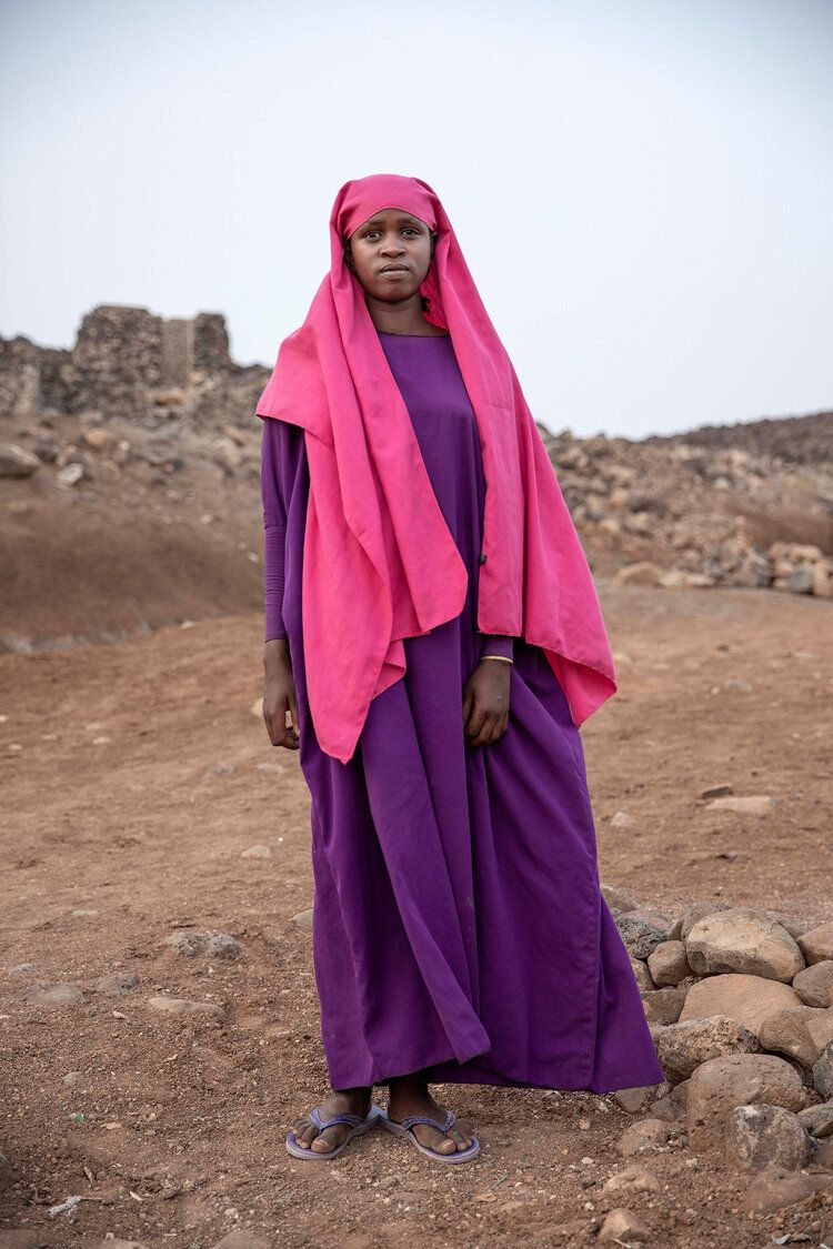 In this July 12, 2019 photo, 17-year-old Ikram Abdi, a migrant from Ethiopia, poses for a photograph at a slum area in Dikhil, Djibouti. Like many of the migrants, she left at dawn without her families' knowledge and hoped for their forgiveness when she starts sending them money from Saudi. Image by Nariman El-Mofty / AP Photo. Djibouti, 2019.