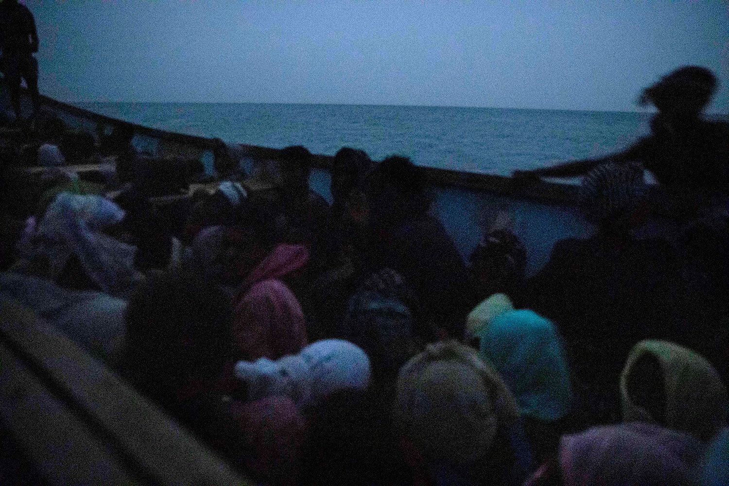 In this July 15, 2019 photo, smugglers ferry Ethiopian migrants in a boat at the uninhabited coast outside the town of Obock, the shore closest to Yemen, in Djibouti. According to the U.N.'s International Organization for Migration the number of women making the trip jumped from nearly 15,000 in 2018 to more than 22,000 in 2019. The number of girls had an enormous increase, quadrupling from 2,075 to 8,360. Despite the many risks – smugglers' exploitation, rape, hunger, drowning – they are undaunted. Image by Nariman El-Mofty / AP Photo. Djibouti, 2019.