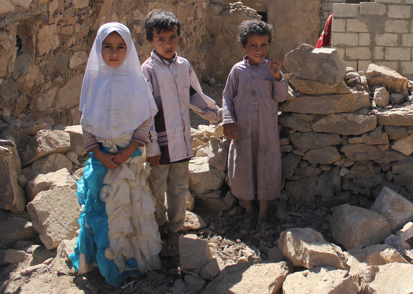 Children stand in the rubble of houses destroyed during a raid by U.S. Navy SEALs in the village of al Ghayil. Image by Iona Craig. Yemen, 2017.