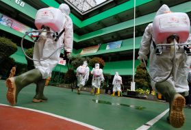 Volunteers from Indonesia's Red Cross prepare to spray disinfectant at a school closed amid the spread of coronavirus (COVID-19) in Jakarta. Image by REUTERS/Willy Kurniawan. Indonesia, 2020. 