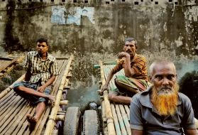 Tannery workers take a break before noon prayers. Their carts can carry a ton of goat skins through the narrow streets of Hazaribagh. Image by Larry C. Price. Bangladesh, 2016.